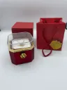Rotating preserved rose gift box set.  It includes a preserved red rose housed in an octagonal, clear-top box with a hidden compartment that  contains a necklace