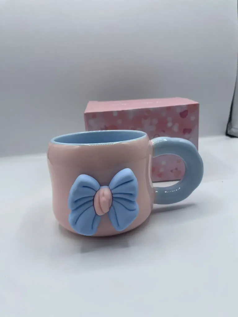 Ceramic coffee mug with a 3D magnetic bow design.