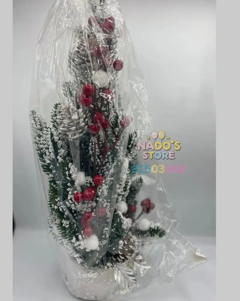 Artificial Christmas tree, decorated with faux snow and red berries. It is a tabletop decoration.